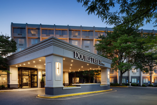 DoubleTree by Hilton hotel entrance at twilight with modern architecture and surrounding trees.