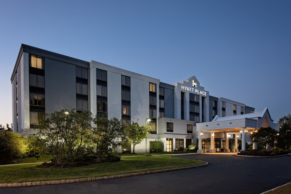 Modern Hyatt Place hotel exterior at dusk with illuminated entrance and landscaping.