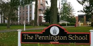 Sign for The Pennington School in front of a large brick building and green lawn.