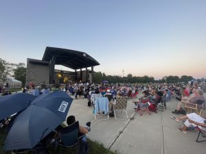 outdoor stage with crowds of people watching a live performance